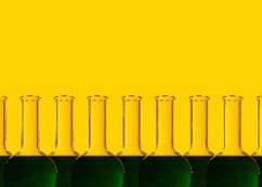 Row of florence flasks with green liquid and yellow background